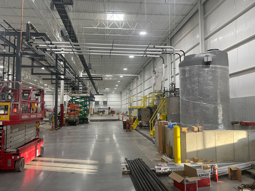 Large industrial manufacturing facility with equipment installation and overhead services
